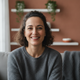 A smiling woman in her mid-30s. Her genuine expression conveys relief and happiness in a clean home setting.
